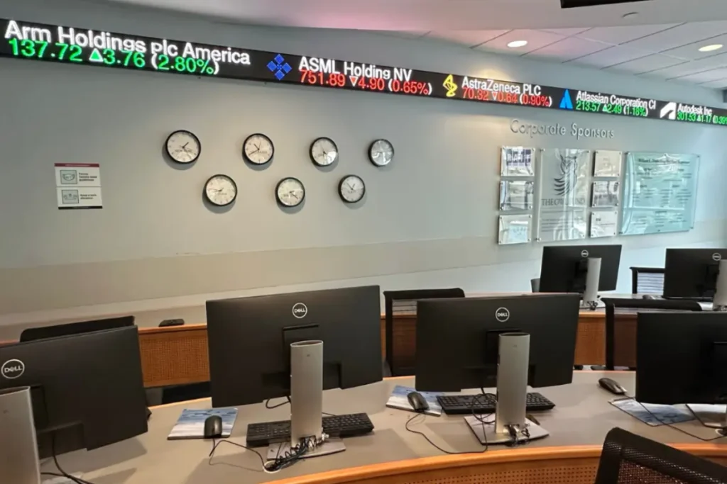A Rise Display ticker mounted to the wall in a university classroom, displaying financial information.